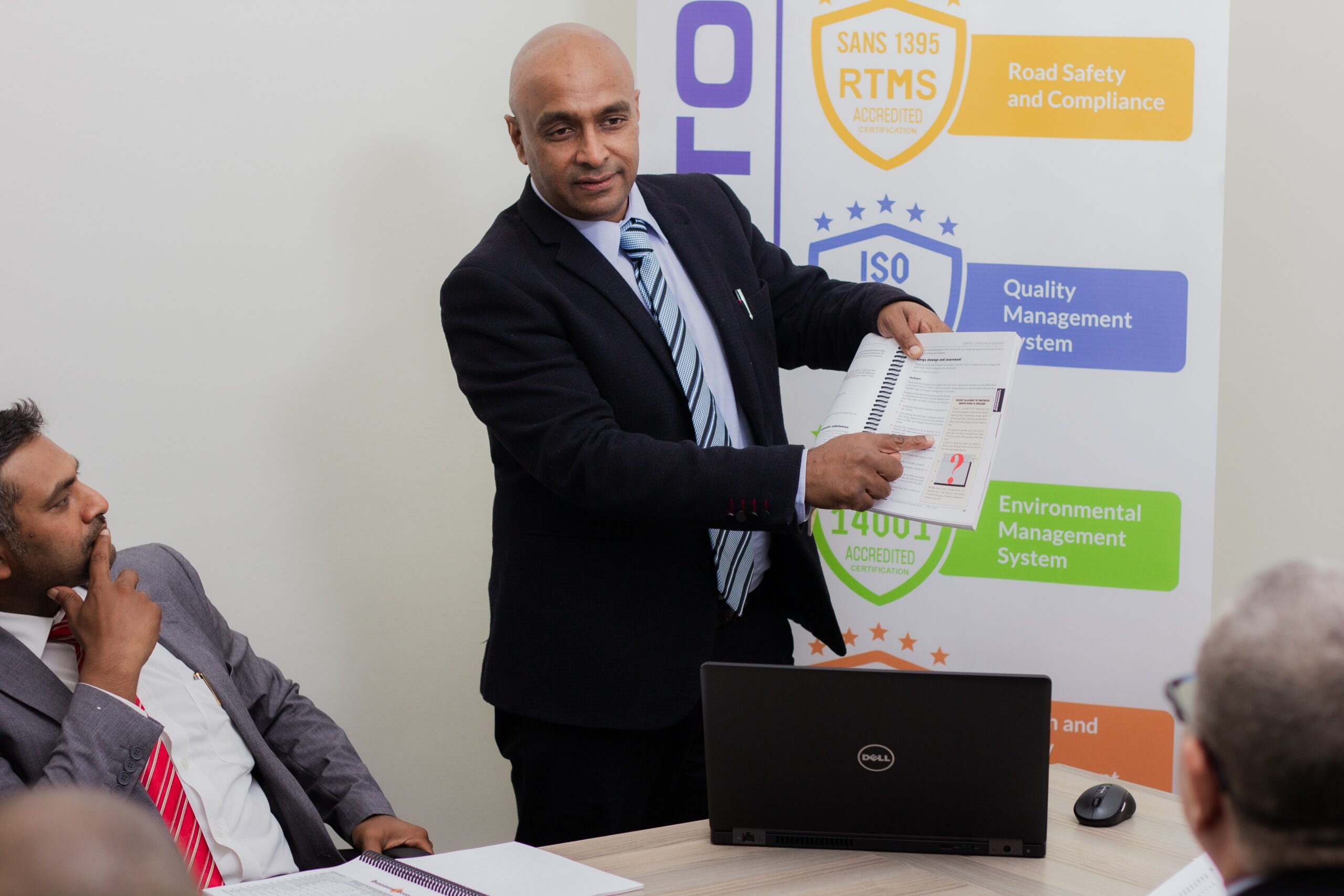Oliver Naidoo holding and pointing to a page in a book