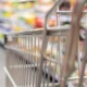 Close up shot of a trolley in a bustling supermarket