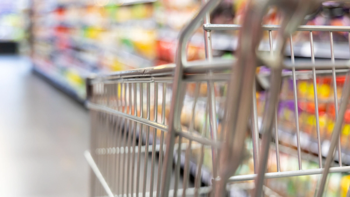 Close up shot of a trolley in a bustling supermarket