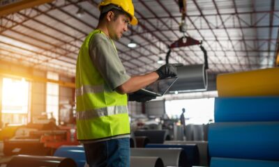 Warehouse worker walking through a warehouse with a laptop
