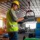 Warehouse worker walking through a warehouse with a laptop