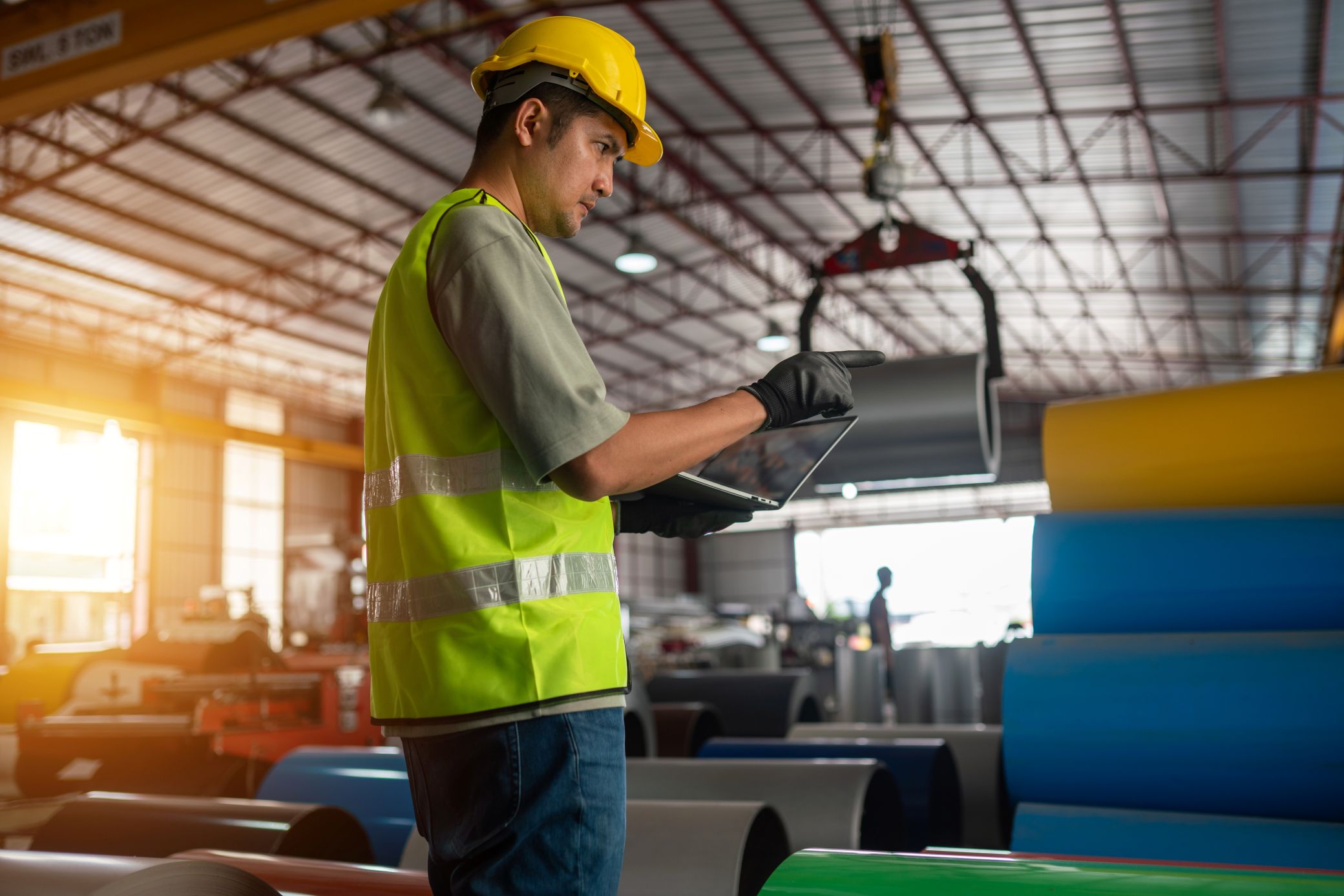 Warehouse worker walking through a warehouse with a laptop