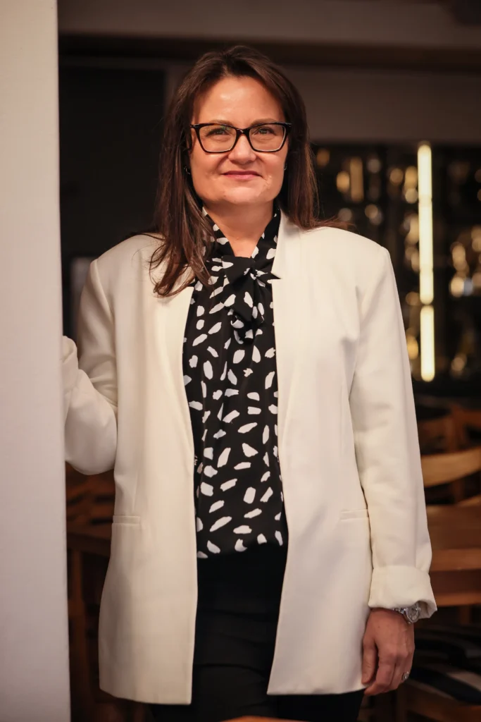Portrait of Odette van Zyl standing in a doorway. 