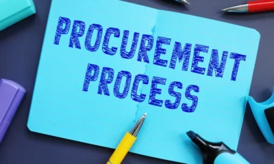 The words ‘Procurement Process’ sketched on a notebook surrounded by pens and highlighters