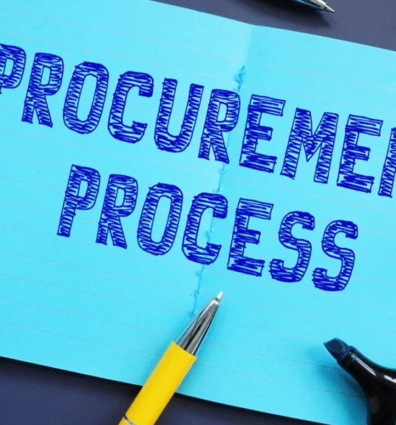 The words ‘Procurement Process’ sketched on a notebook surrounded by pens and highlighters