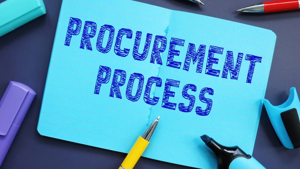 The words ‘Procurement Process’ sketched on a notebook surrounded by pens and highlighters