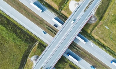 Aerial shot of a bustling highway with freight trucks transporting goods.