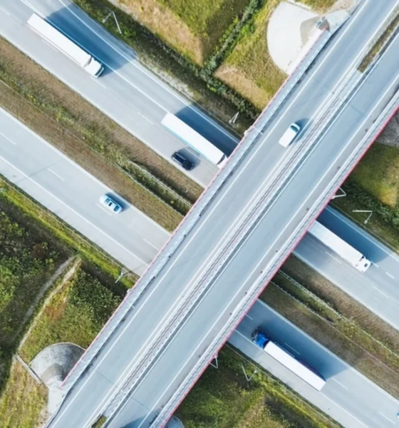 Aerial shot of a bustling highway with freight trucks transporting goods.