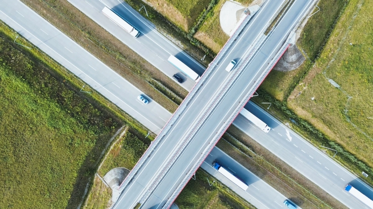 Aerial shot of a bustling highway with freight trucks transporting goods.