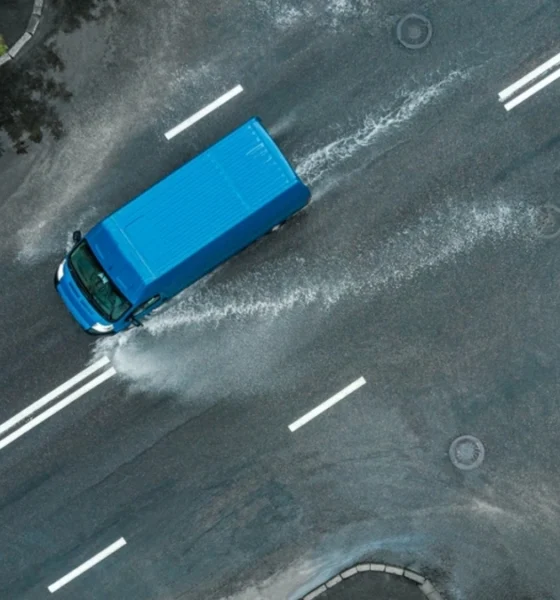 Aerial shot of a blue delivery van driving in a heavy storm.