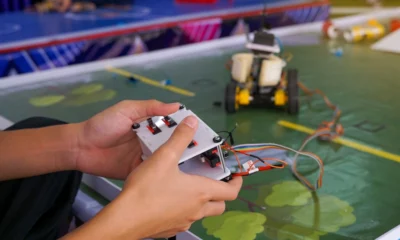 Close up of a high school controlling a remote-control car at a competition.