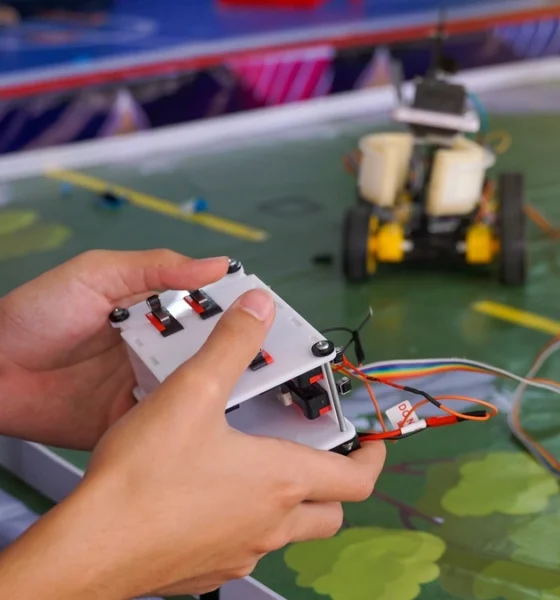 Close up of a high school controlling a remote-control car at a competition.