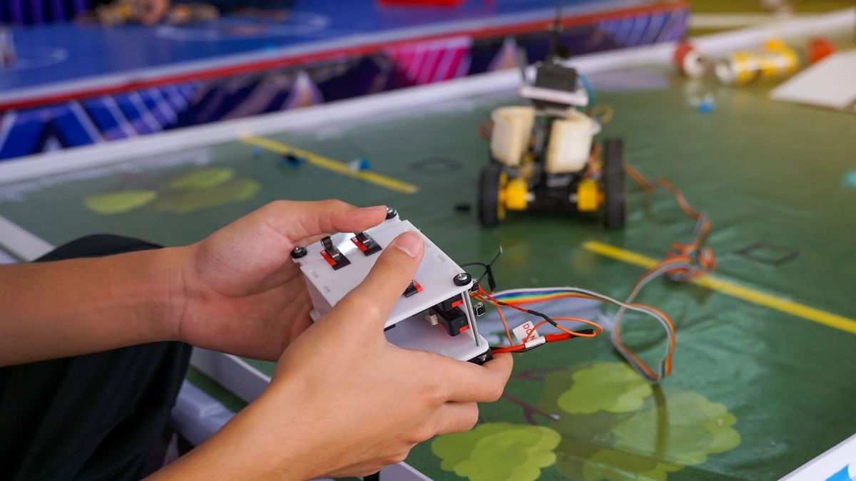 Close up of a high school controlling a remote-control car at a competition.