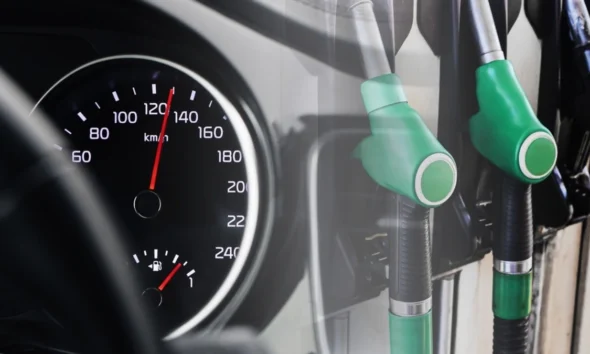 Fuel pomp nozzles beside a car dashboard speedometer showing a full petrol