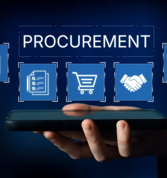 Man holding phone face up with a hologram of procurement icons displaying from it