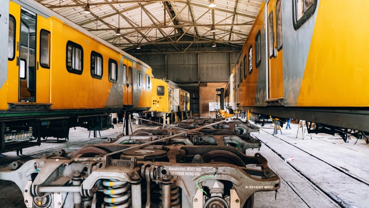 South African yellow and grey trains parked in a service yard.