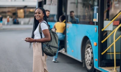 Smiling as she boards a public bus.