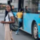 Smiling as she boards a public bus.