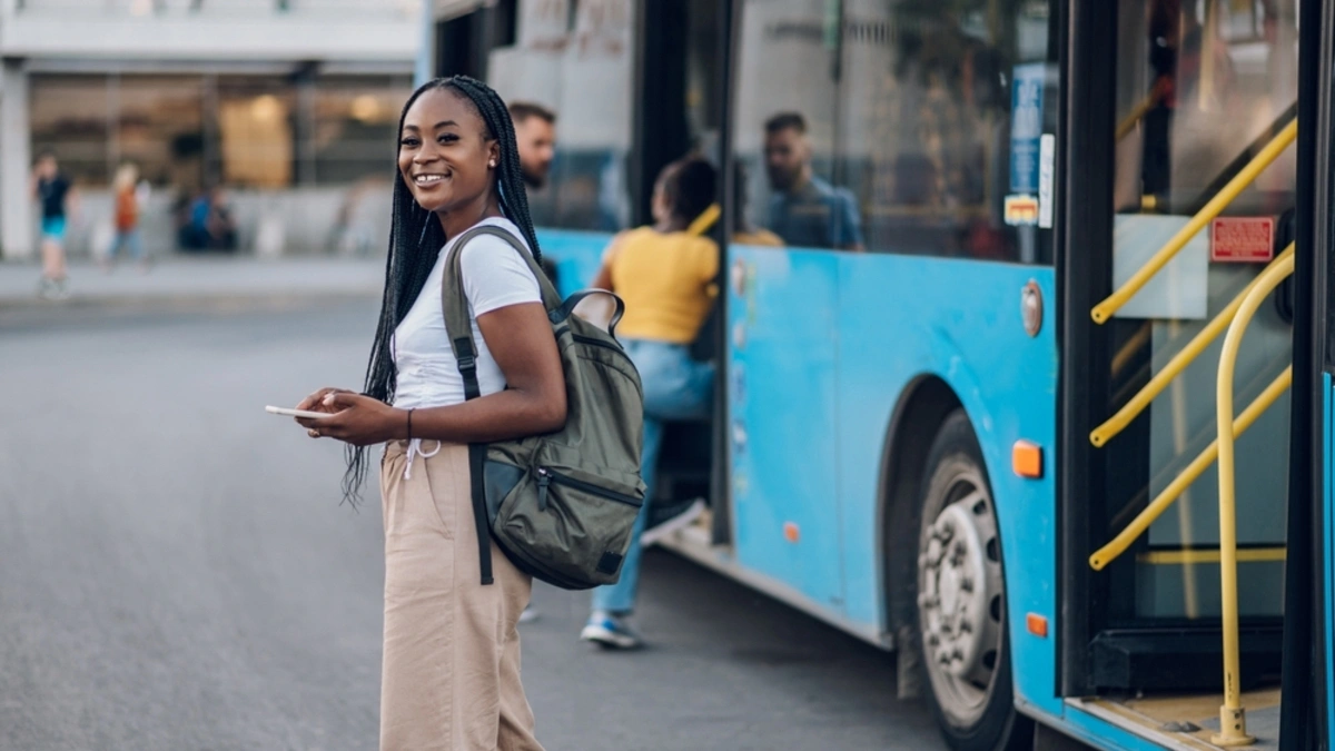 Smiling as she boards a public bus.