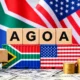 A South African and US flag sitting on a desk with toy freight vehicles transporting goods. In the centre, lies two shipping containers painted with a South African and US flag with letters on top spelling AGOA.