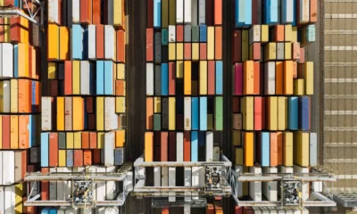 Aerial shot of stacked shipping containers in a shipping yard.
