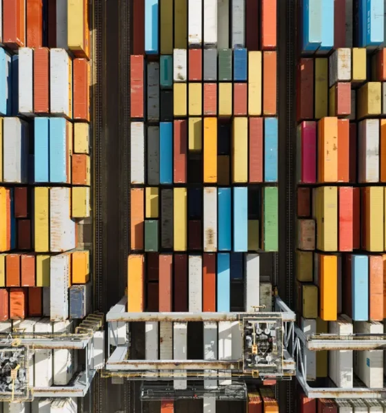 Aerial shot of stacked shipping containers in a shipping yard.