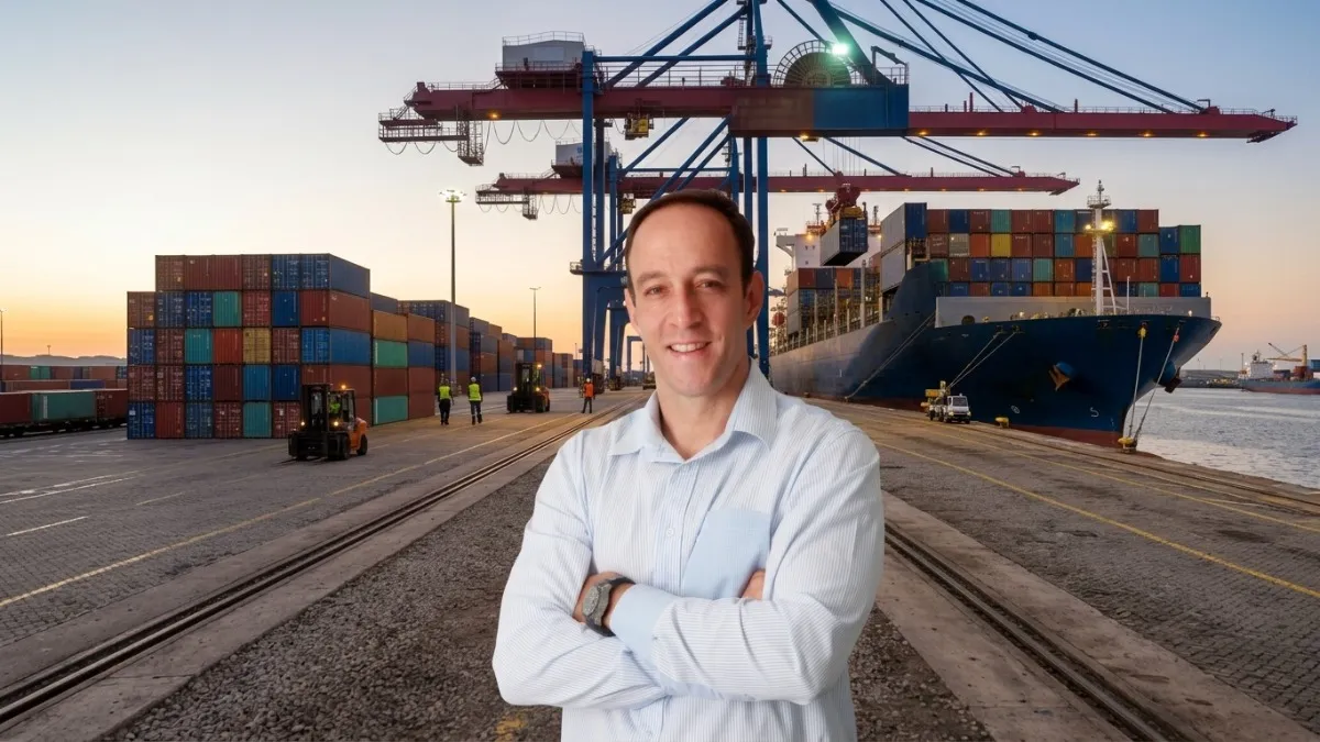 Roy Alves posing in a shipping yard in front of a freight ship.