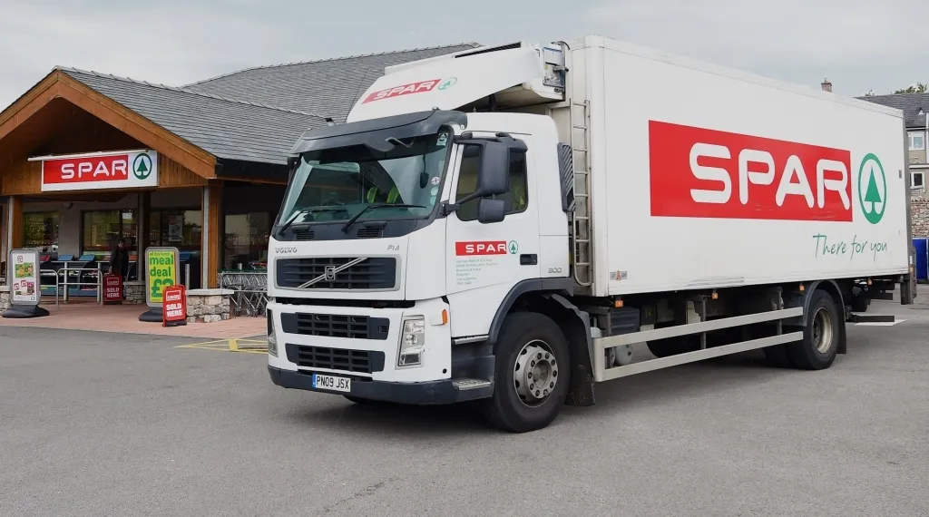A SPAR delivery truck parked outside of a SPAR store.